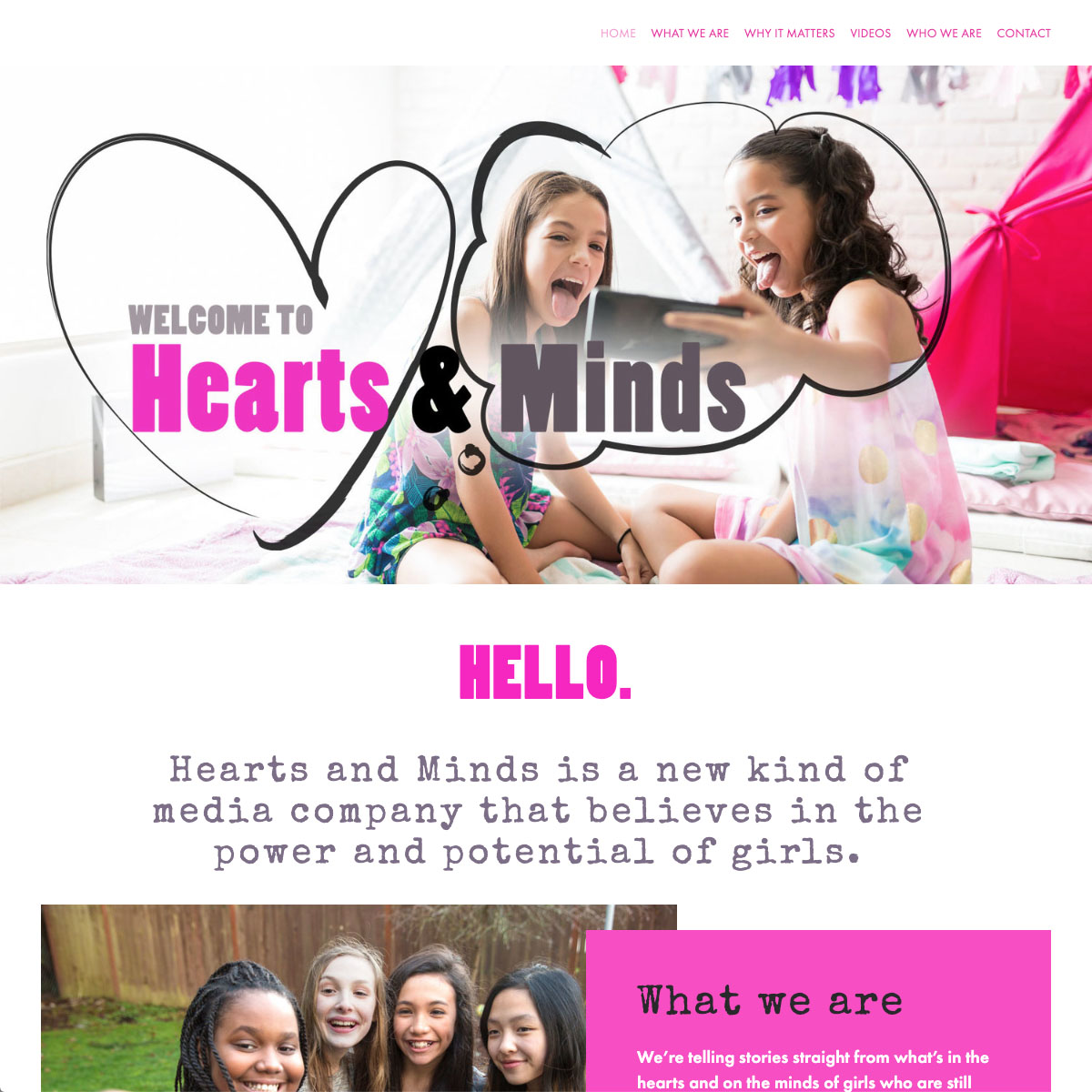 screenshot of the Hearts and Minds homepage showing a hero image of two girls sticking their tongues out while taking a selfie